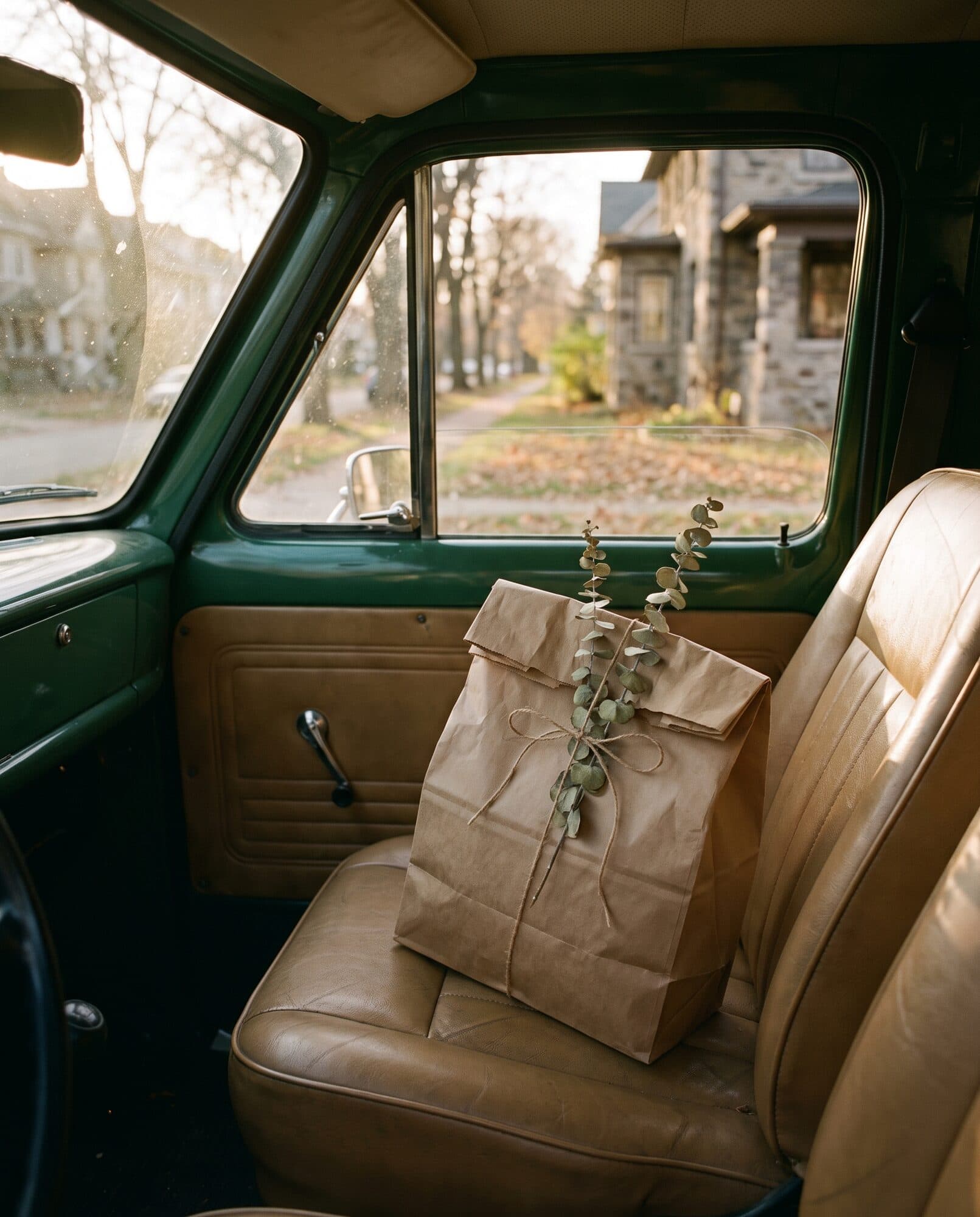 A kraft-paper prescription bag riding on the seat of our green delivery van