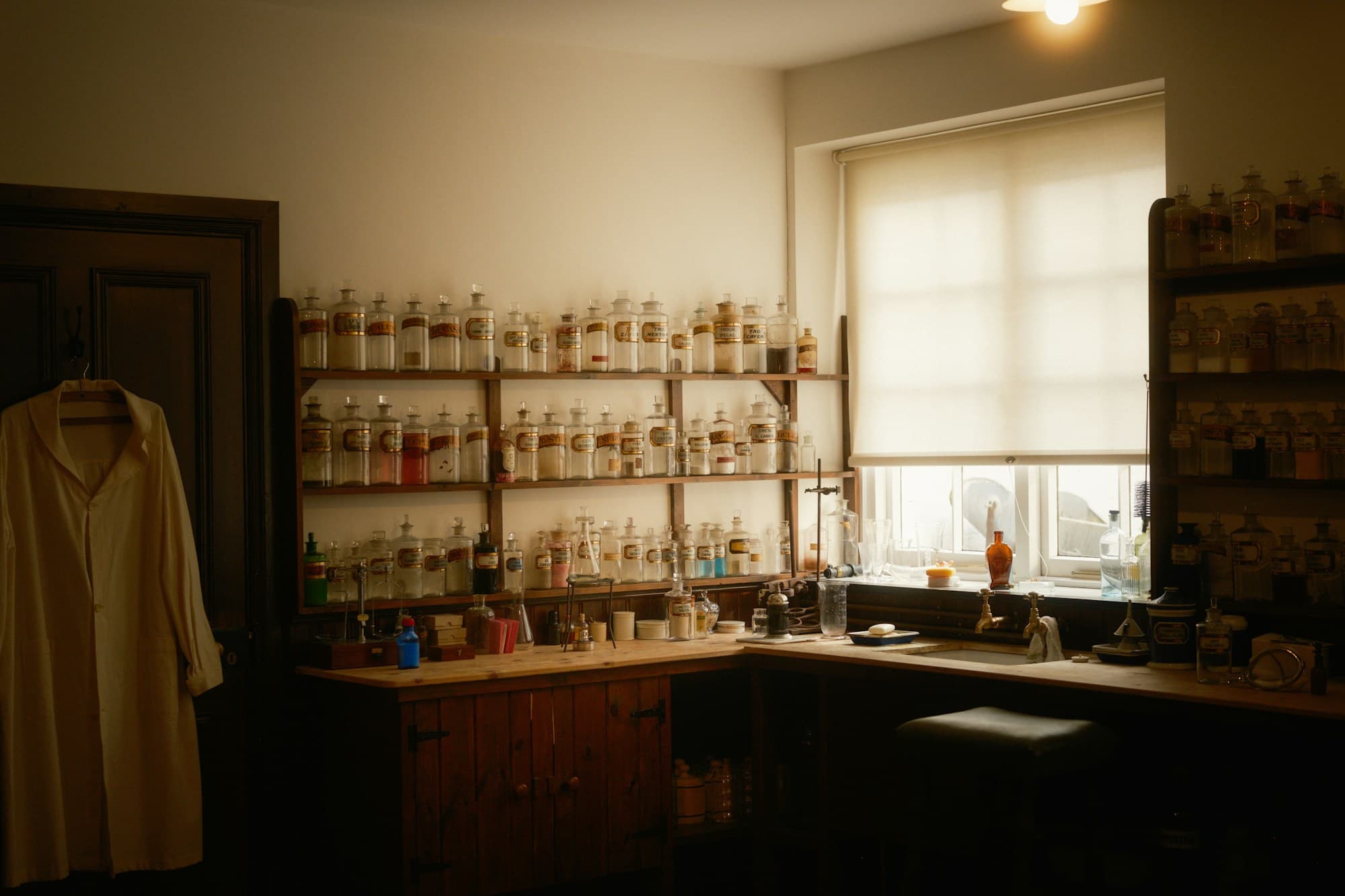 The compounding room at the pharmacy — wooden shelves lined with apothecary bottles beside a sunlit window